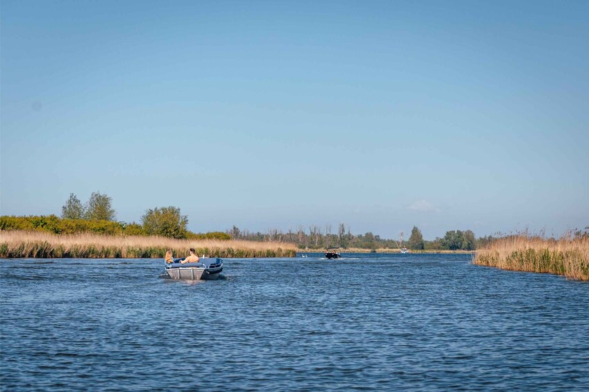 A calm river with a boat carrying two people. 4