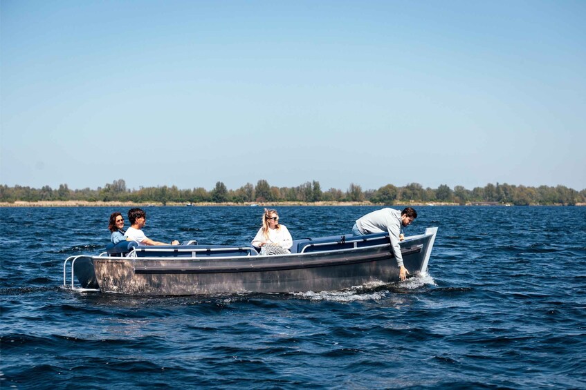 A small boat on a body of water with three people on board. 3