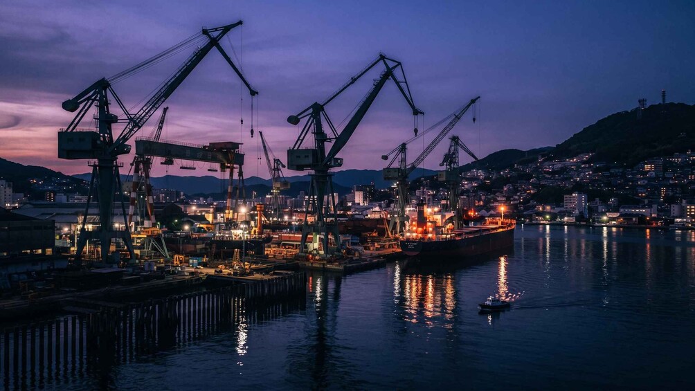 A harbor at dusk with cranes and a large ship docked. 3