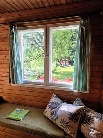 A wooden cabin with a window overlooking a garden. 5