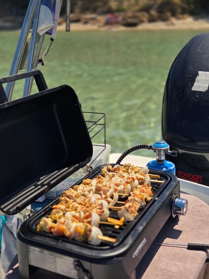 A portable grill with skewers of food on a boat. 5