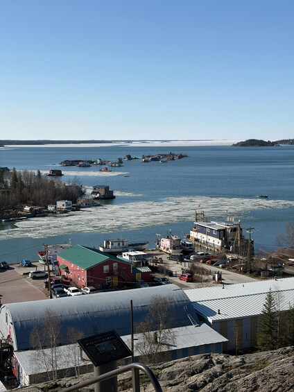 A coastal town with a marina, boats, and a rocky shoreline. 2