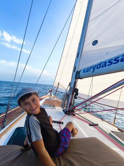 A person on a sailboat with a clear sky and calm sea. 3
