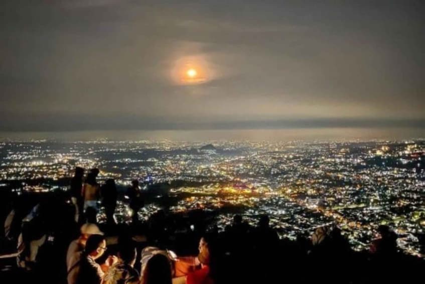 A cityscape at night with a visible moon in the sky. 5