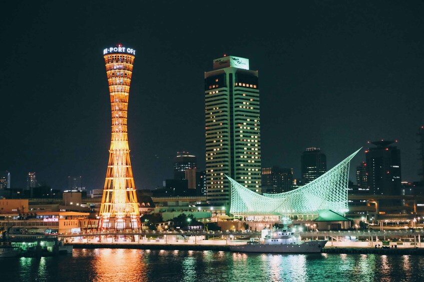 A city skyline at night with illuminated landmarks including a tall tower, a green-lit bridge, and a high-rise building. 3