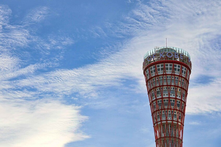 A tall, cylindrical tower with a red and white color scheme, featuring a sign with the letters 'OFKOBE' at the top. 2