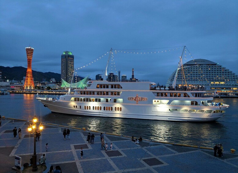 A cruise ship named 'CONCERTO' docked at a port with a city skyline in the background, including a tall tower and a bridge. 5