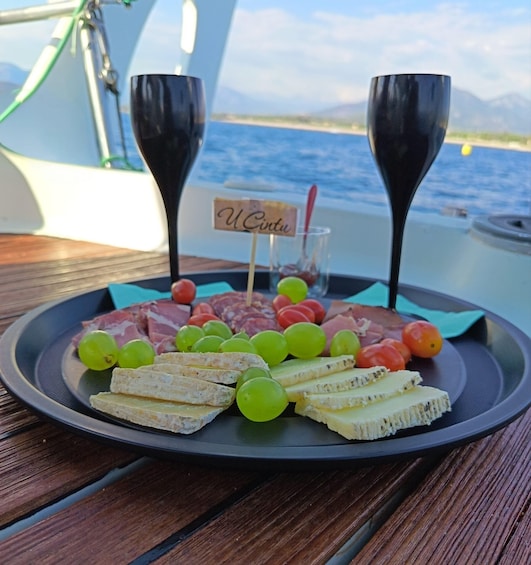 A charcuterie board with various meats, cheeses, and grapes on a boat deck. 4