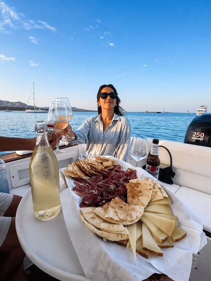 A person on a boat with a table set with food and drinks. 2