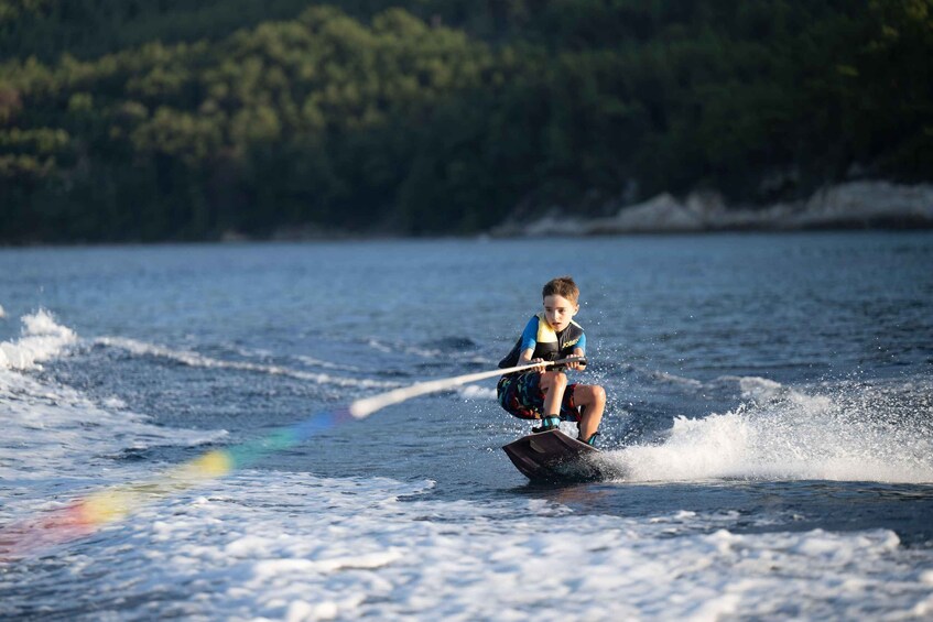 A person wakeboarding on a body of water with waves. 1