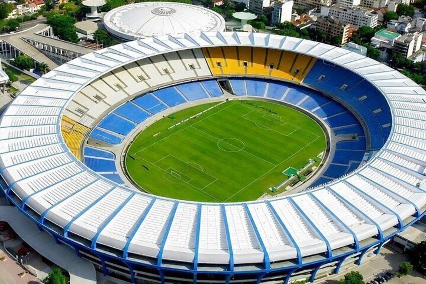 A large stadium with a circular design, featuring multiple tiers of seating and a central field. 1