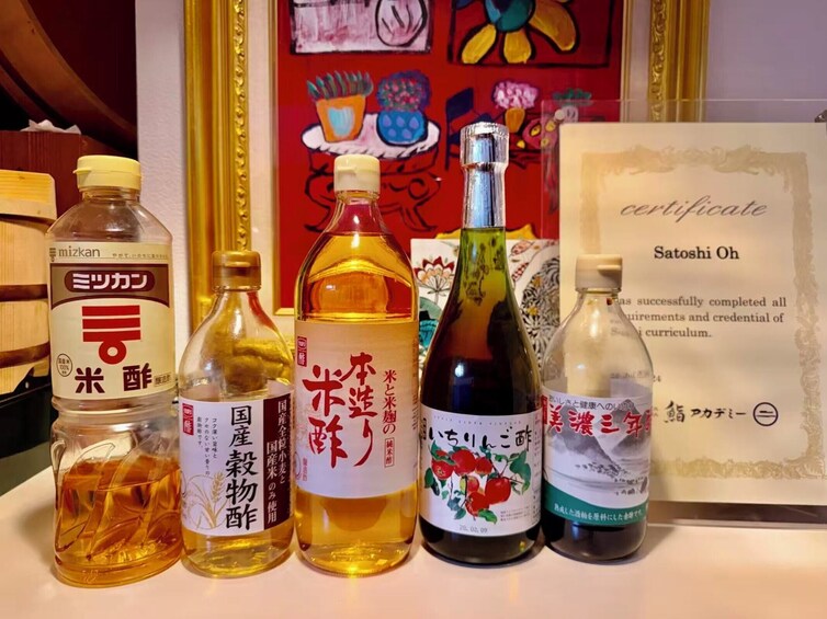 Forskellige flasker med japanske drikkevarer og et certifikat. 2
