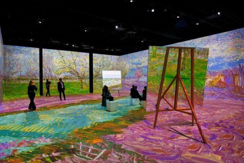 An art gallery with a large painting on the wall and a canvas on an easel. 3