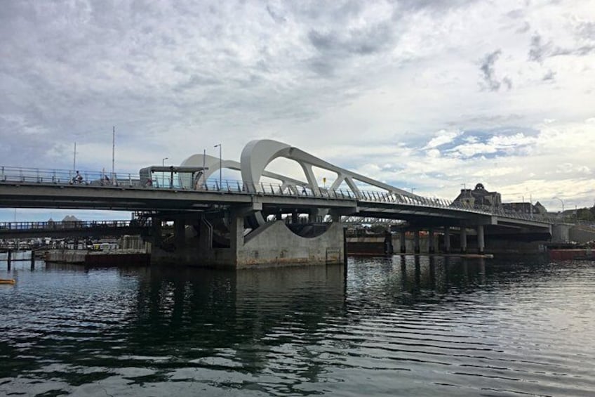 A bridge with a unique design, a body of water below, and a cloudy sky. 4