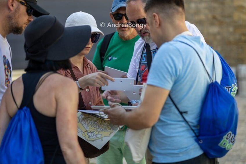 A group of people gathered around a map, possibly tourists. 1