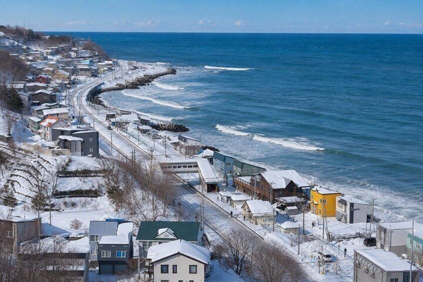 A coastal town with snow-covered buildings and a beach. 5