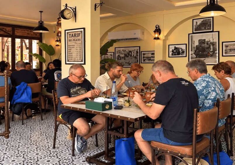 A group of people dining at a restaurant with a tiled floor and vintage decor. 3