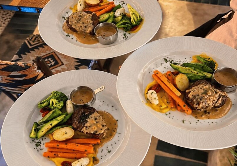 Three plates of food with meat, vegetables, and gravy. 4