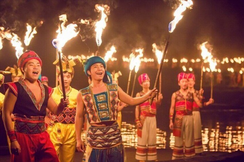 A group of people performing a traditional dance with torches. 3