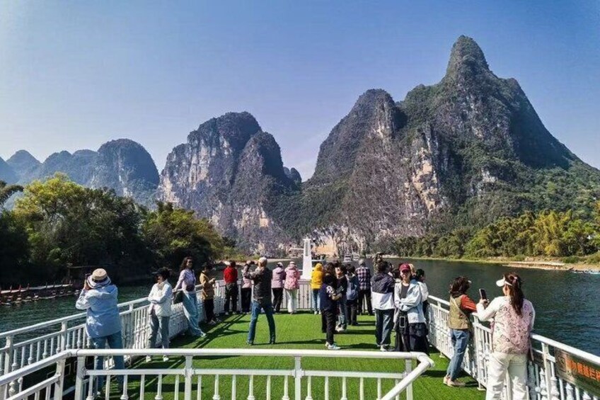 A boat tour with passengers observing a mountainous landscape. 5