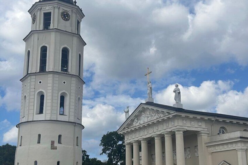 A church with a bell tower and statues on top. 3