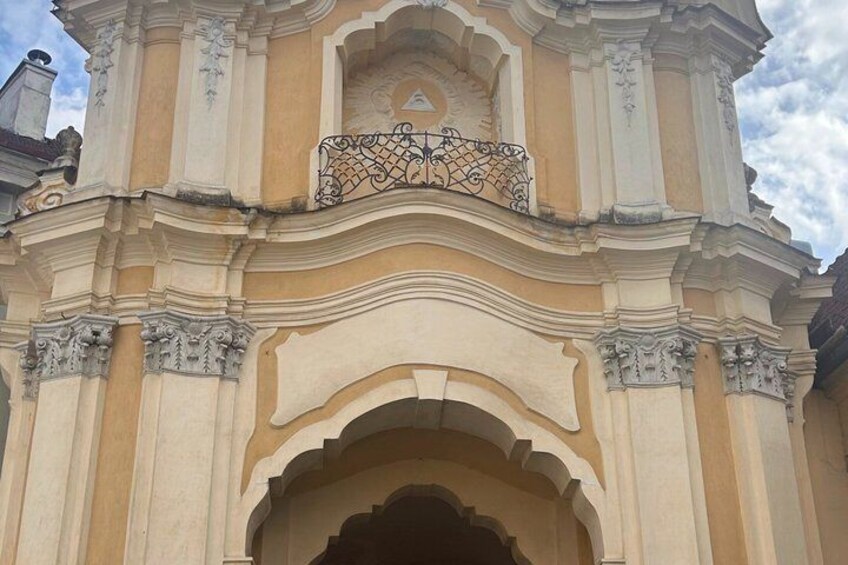 A building with ornate architectural details, including a decorative balcony and a large arched entrance. 4