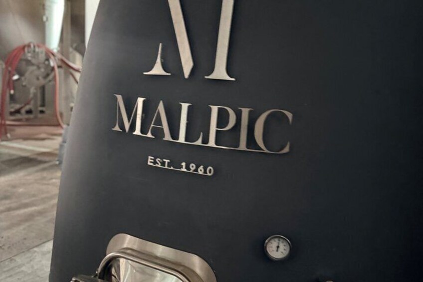 A black vehicle with the text 'MALPIC EST. 1960' and a gauge on the side. 4