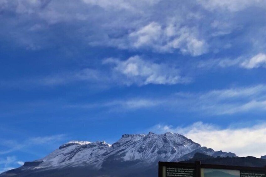 A snow-covered mountain under a blue sky with clouds. 4