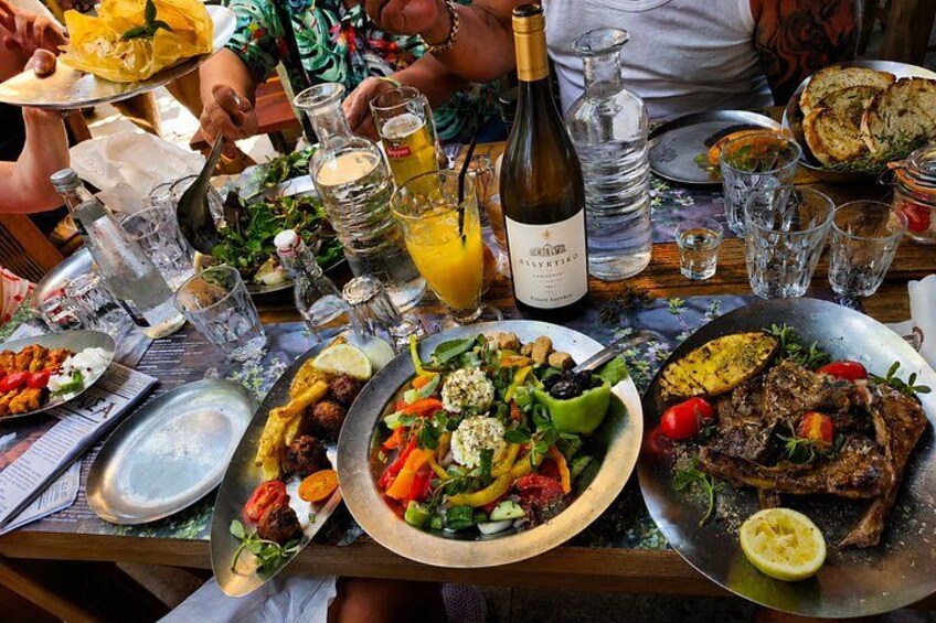 A table with various dishes, drinks, and a bottle of wine. 2