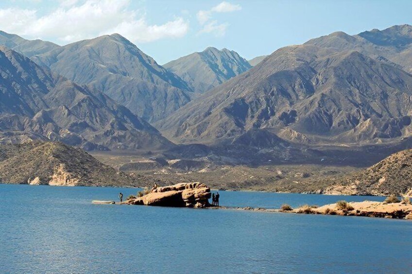 A lake with mountains in the background and a rocky outcrop in the foreground. 1