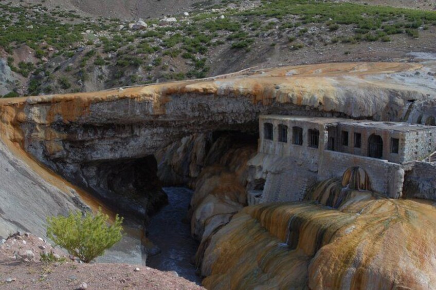 A geological formation with layered rock colors and a man-made structure. 5