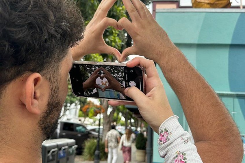 A person taking a photo with a smartphone, holding it up to their face. 1