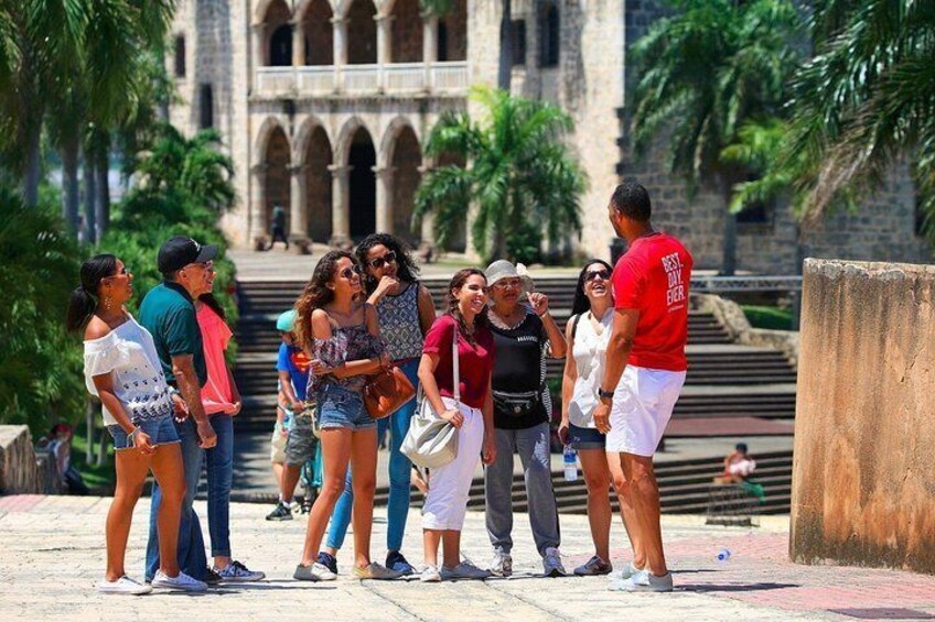 A group of people standing on a stone pathway with a historic building in the background. 3