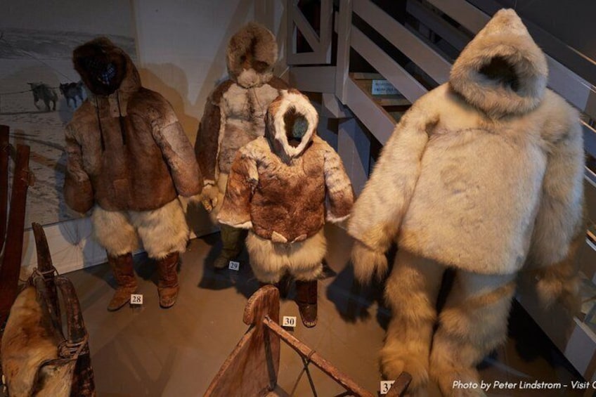 Four fur-covered mannequins in a museum setting. 3