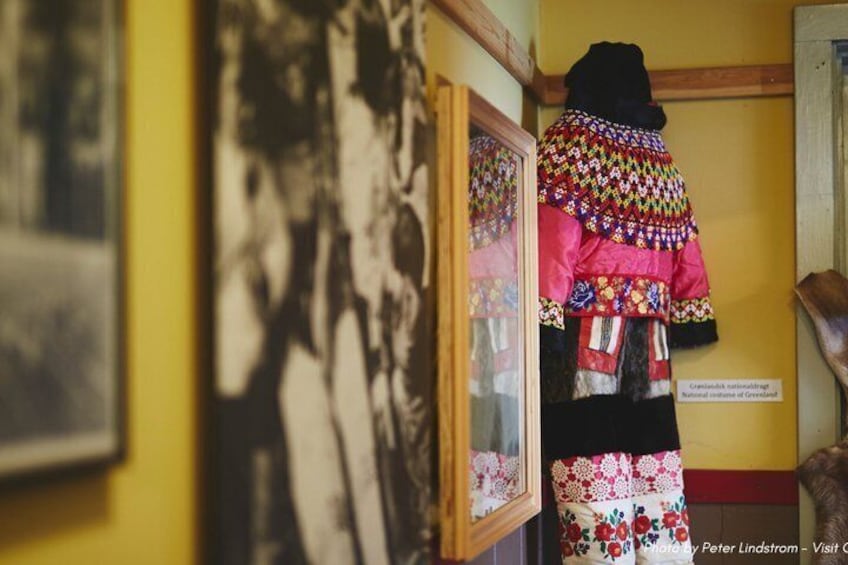 A colorful traditional garment on display in a museum. 4