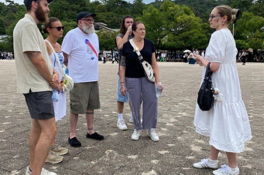 A group of people standing in a public square with trees in the background. 2