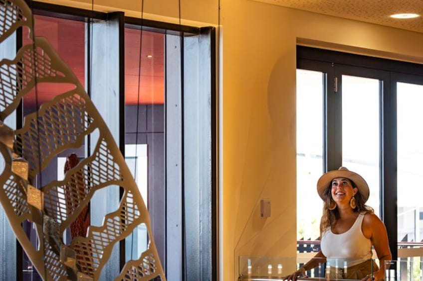 A person standing near a window with a decorative metal structure. 4