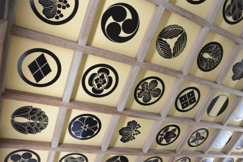 A ceiling with a grid of square panels, each featuring a unique black design. 4