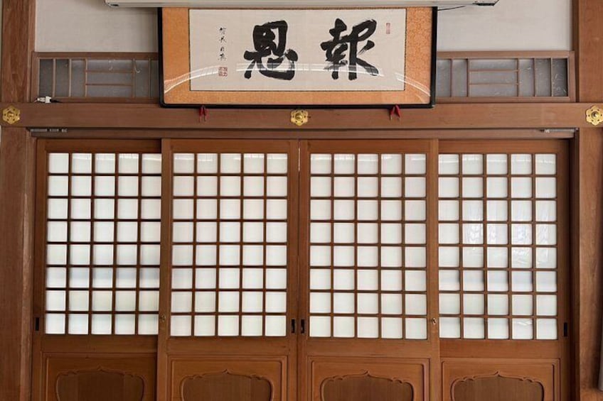 A traditional Japanese sliding door with a sign above it. 2