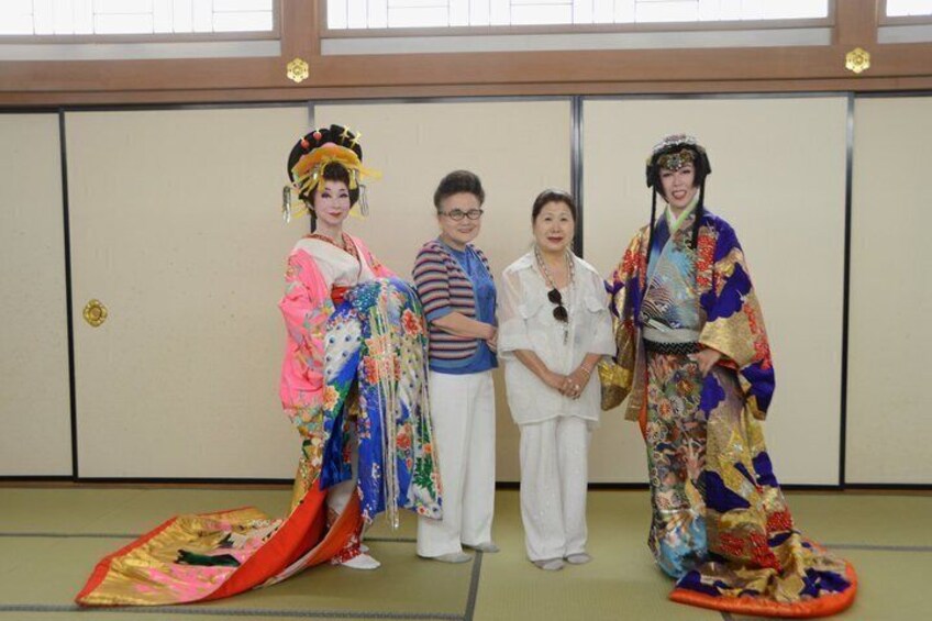 Four people in traditional Japanese attire standing in front of a shoji screen. 3