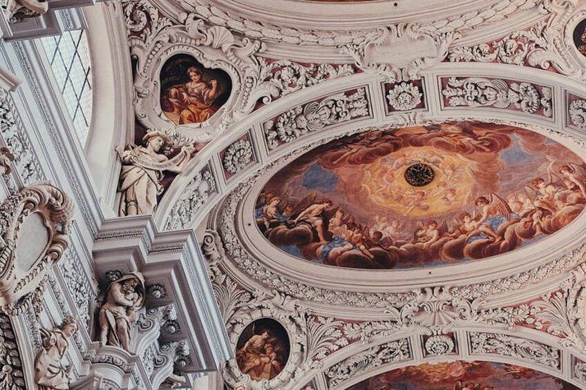 An ornate ceiling with intricate frescoes and architectural details. 2