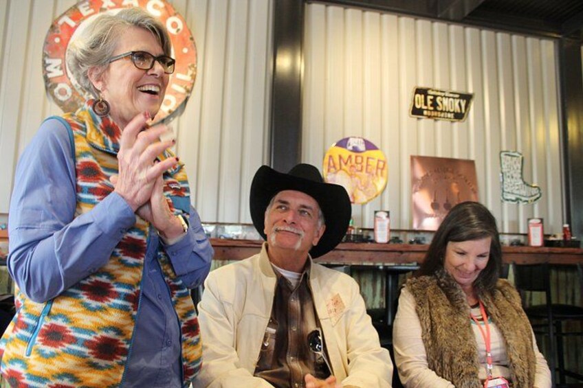 A person in a colorful vest, a person in a cowboy hat, and a person in a fur vest. 5