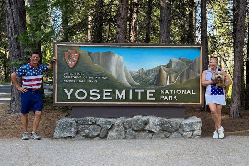 A sign for Yosemite National Park with a depiction of a waterfall and mountains. 4