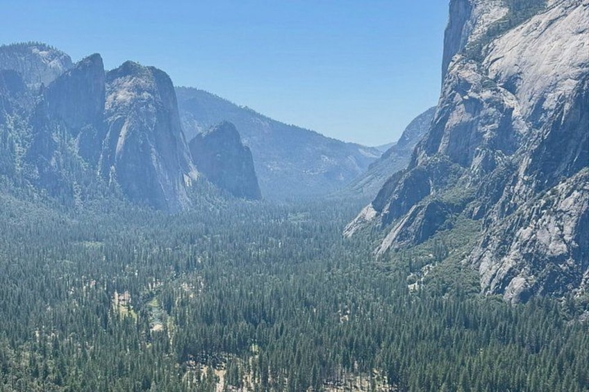 A mountainous landscape with dense forests and prominent rock formations. 2