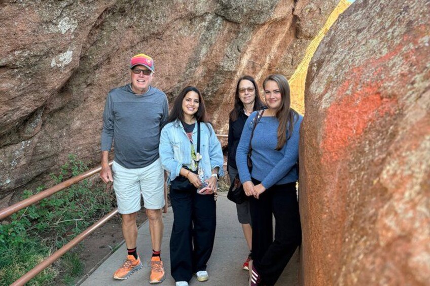 A group of people standing on a pathway with a rocky background. 3