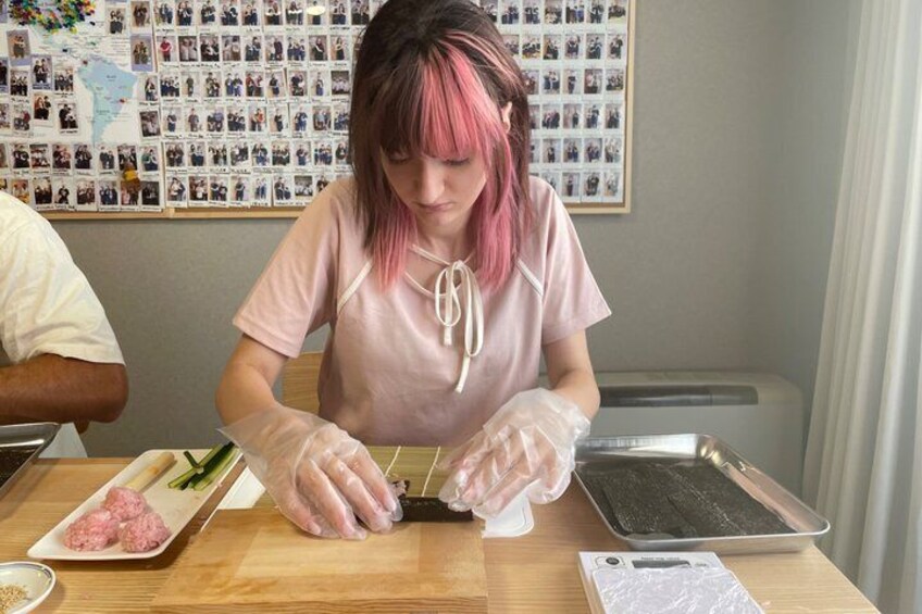 A person preparing food, wearing gloves, with a cutting board, a tray, and a plate of meat visible. 5