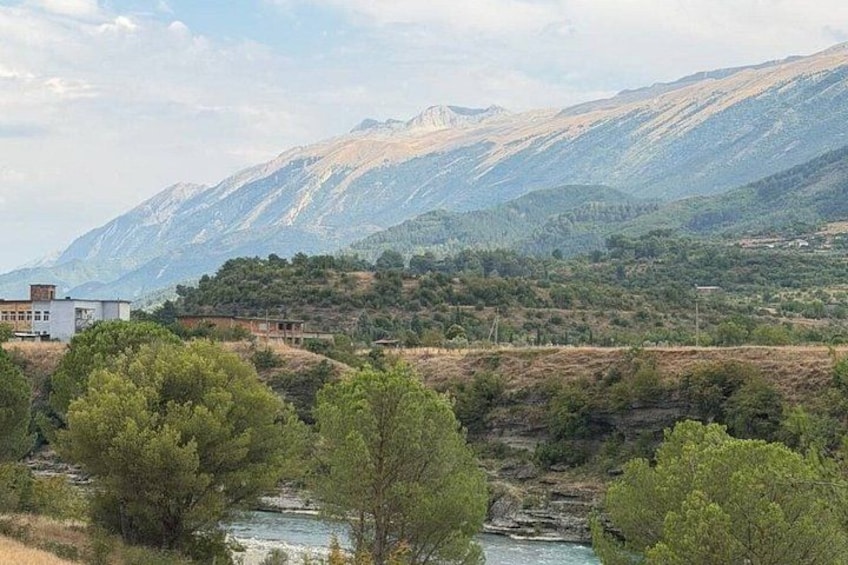 A river, trees, a building, and mountains. 5
