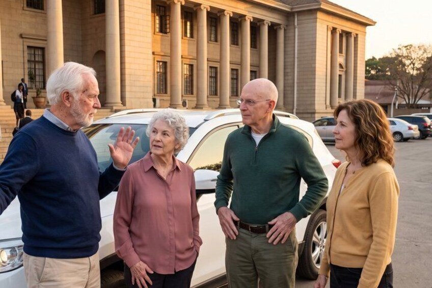 Four people standing in front of a building with columns. 5