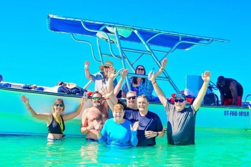 A group of people on a boat in clear blue water. 1