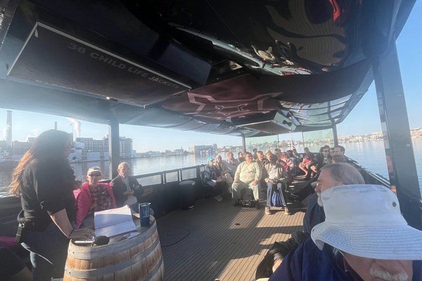 A group of people on a boat with a cityscape in the background. 4